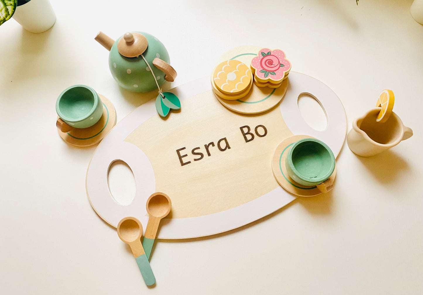 A wooden tea party set in green with cups, kettle, snacks and serving tray. Toy for kids 1 year or older