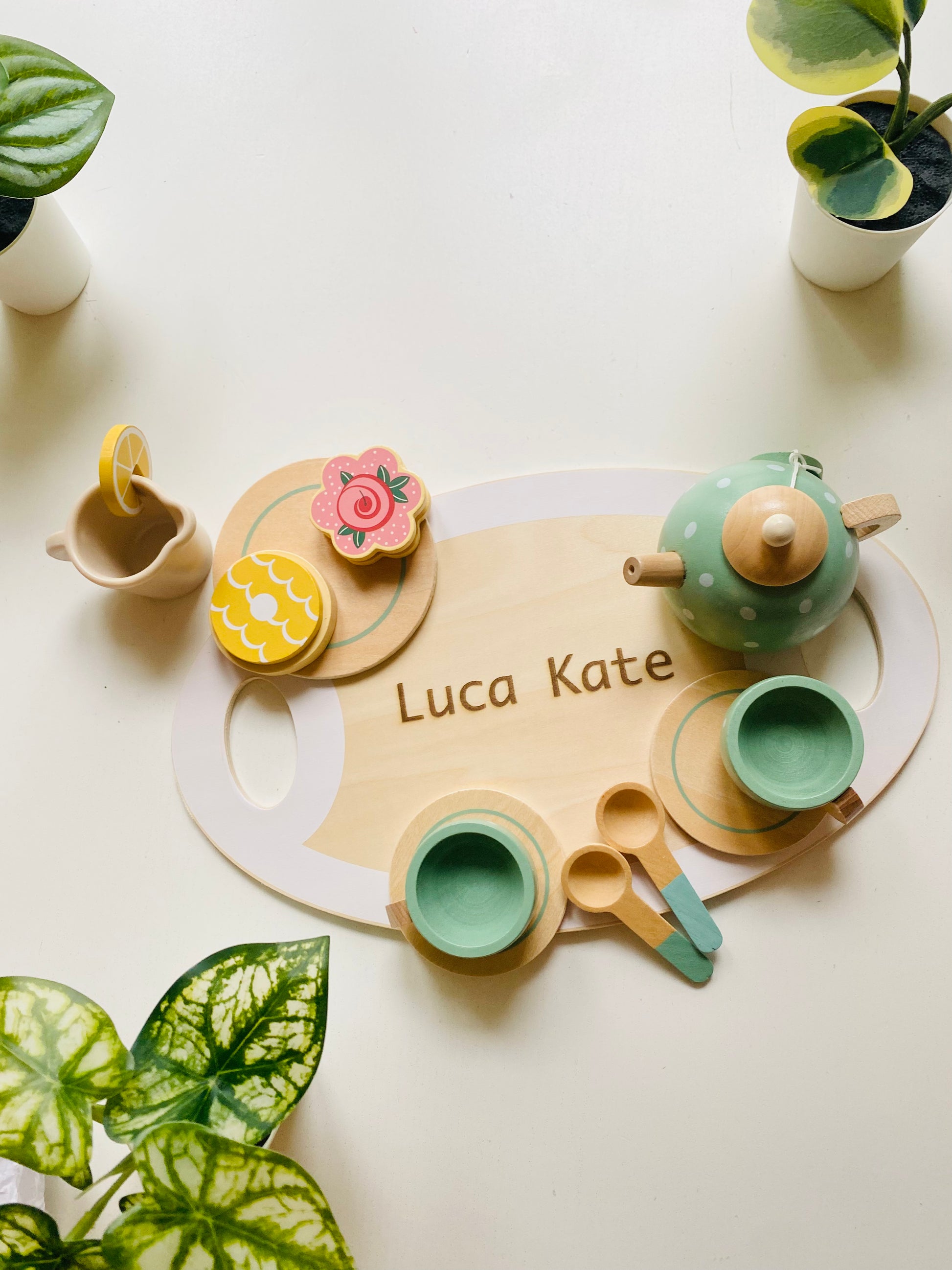 A wooden tea party set in green with cups, kettle, snacks and serving tray. Toy for kids 1 year or older