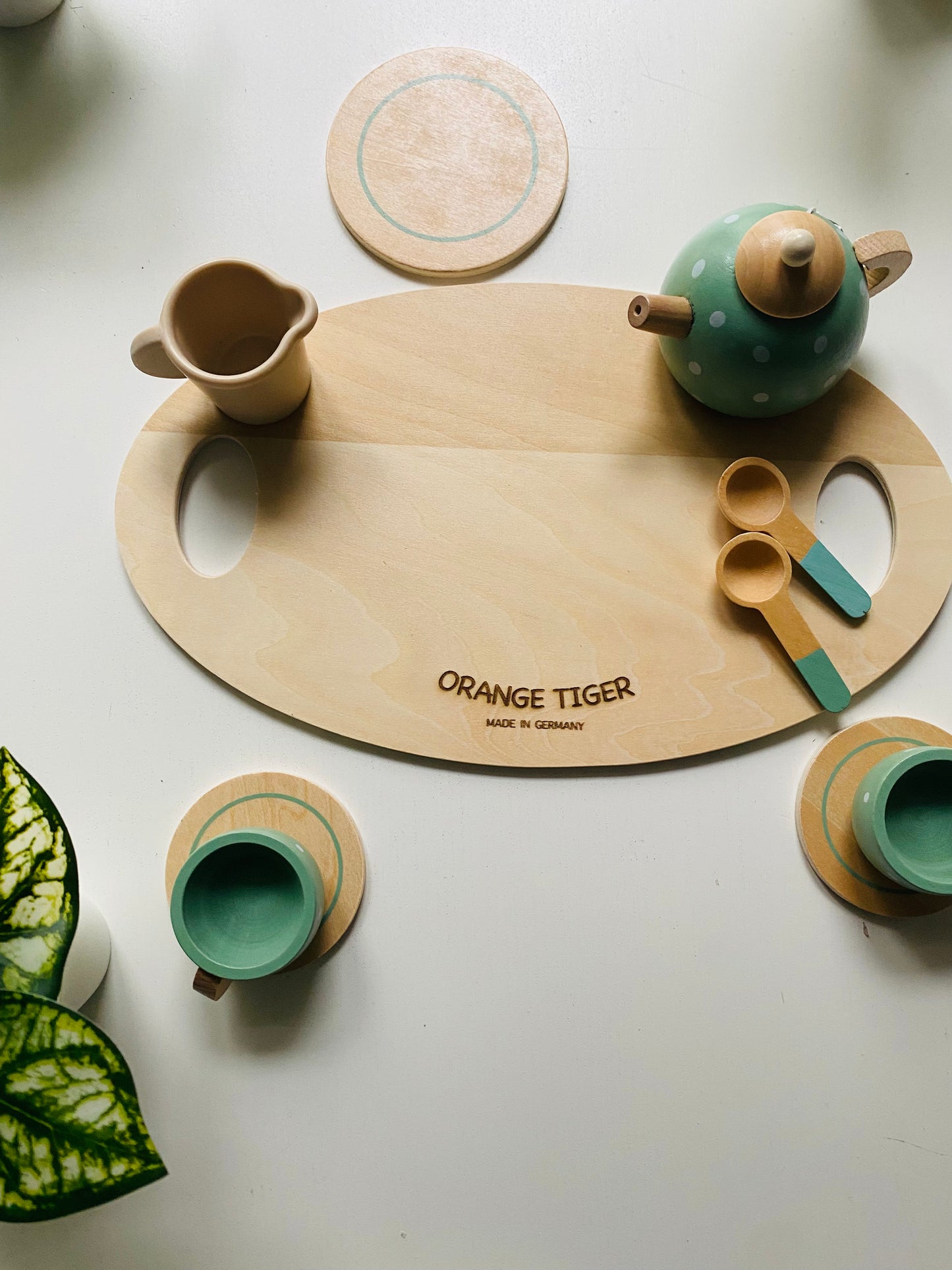 A wooden tea party set in green with cups, kettle, snacks and serving tray. Toy for kids 1 year or older