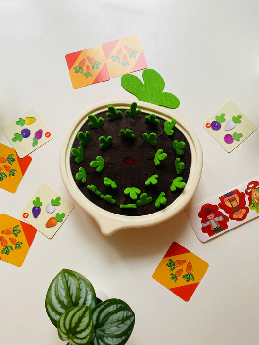 montessori spielzug with white base and brown fabric mud with green shoots coming out.