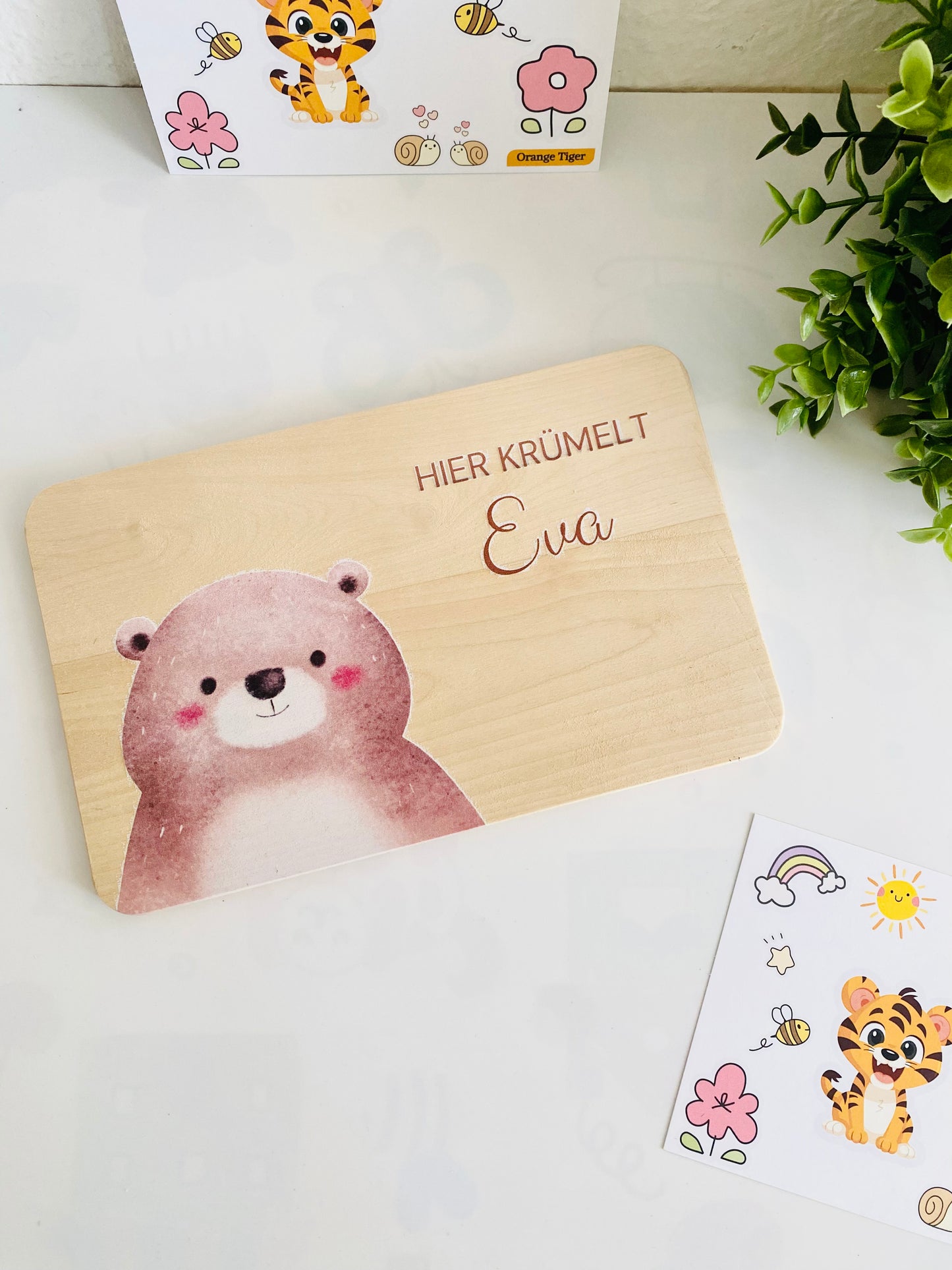 a brown bear breakfast board with "here crumble" written. The board is beige in color and made of beechwood. A unique gift. "Hier Krümelt" brotzeitbrett kinder.